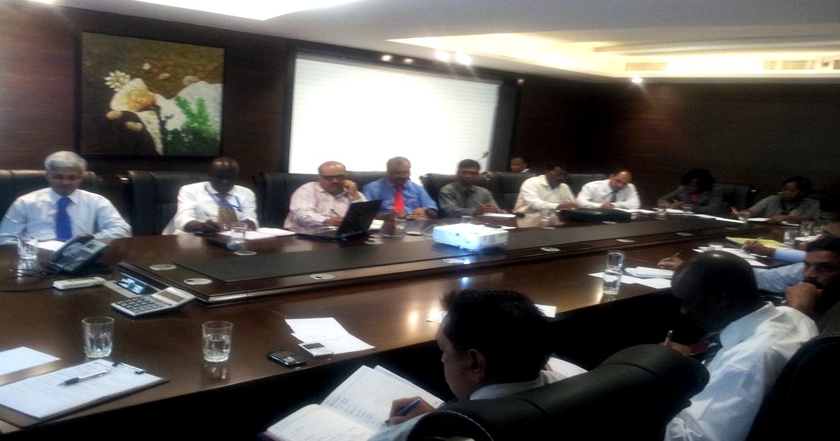 Vijay Mistri in a boardroom reviewing leadership patterns and financial data with senior executives